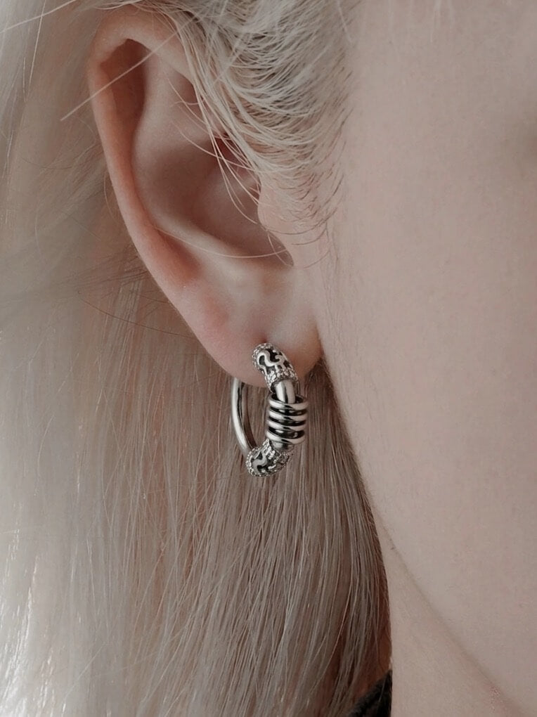 Close-up on-ear model wearing a thick stainless steel gothic hoop, alternative aesthetic street style earring, waterproof durable huggie jewelry.