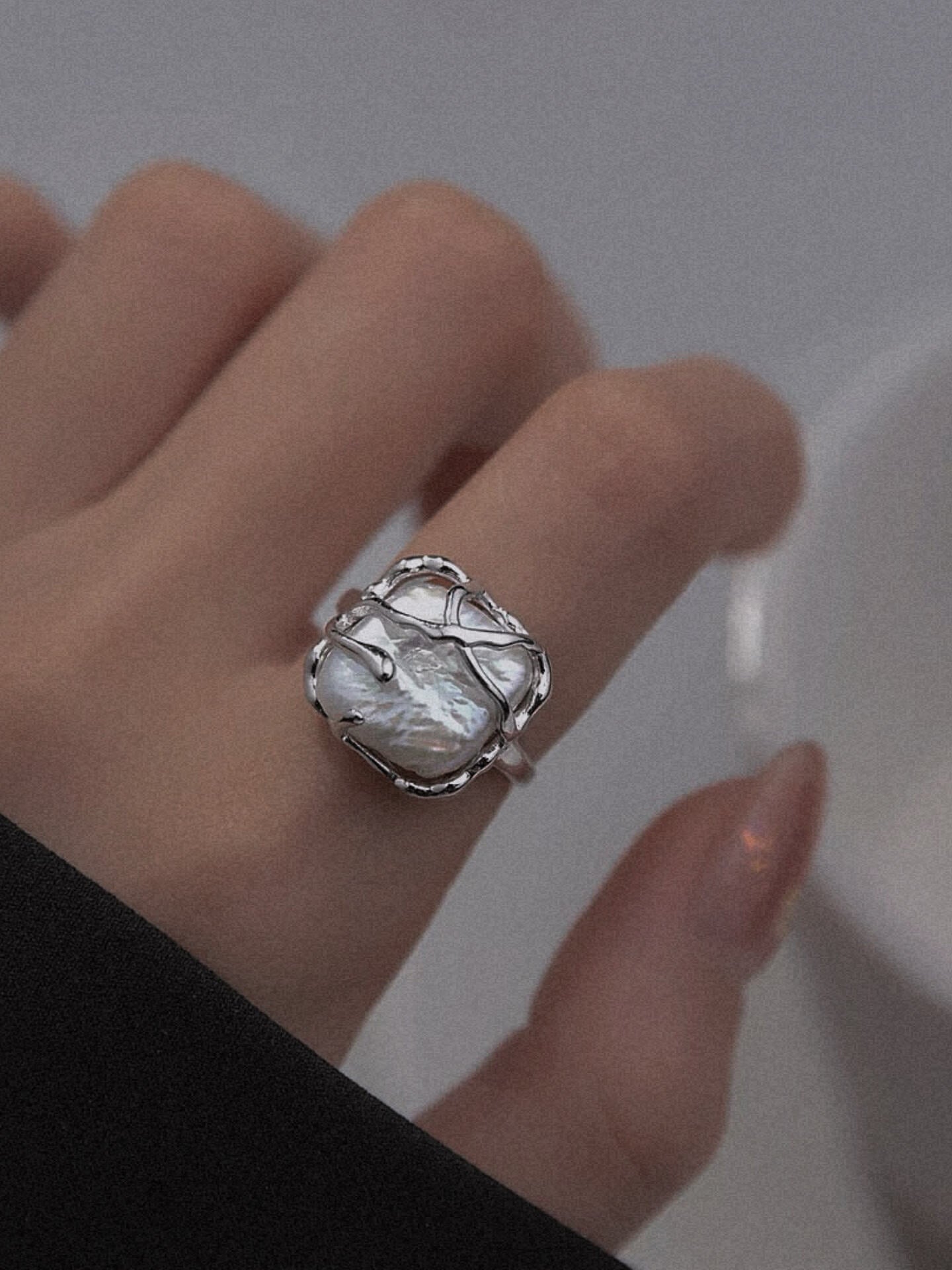 Modern architectural silver ring with iridescent shell center, clean geometric aesthetic for edgy streetwear.