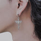 Close-up of model wearing Seraphim Blade winged earrings, long silver tassel wing drops, hypoallergenic stainless steel jewelry for alternative luxury.