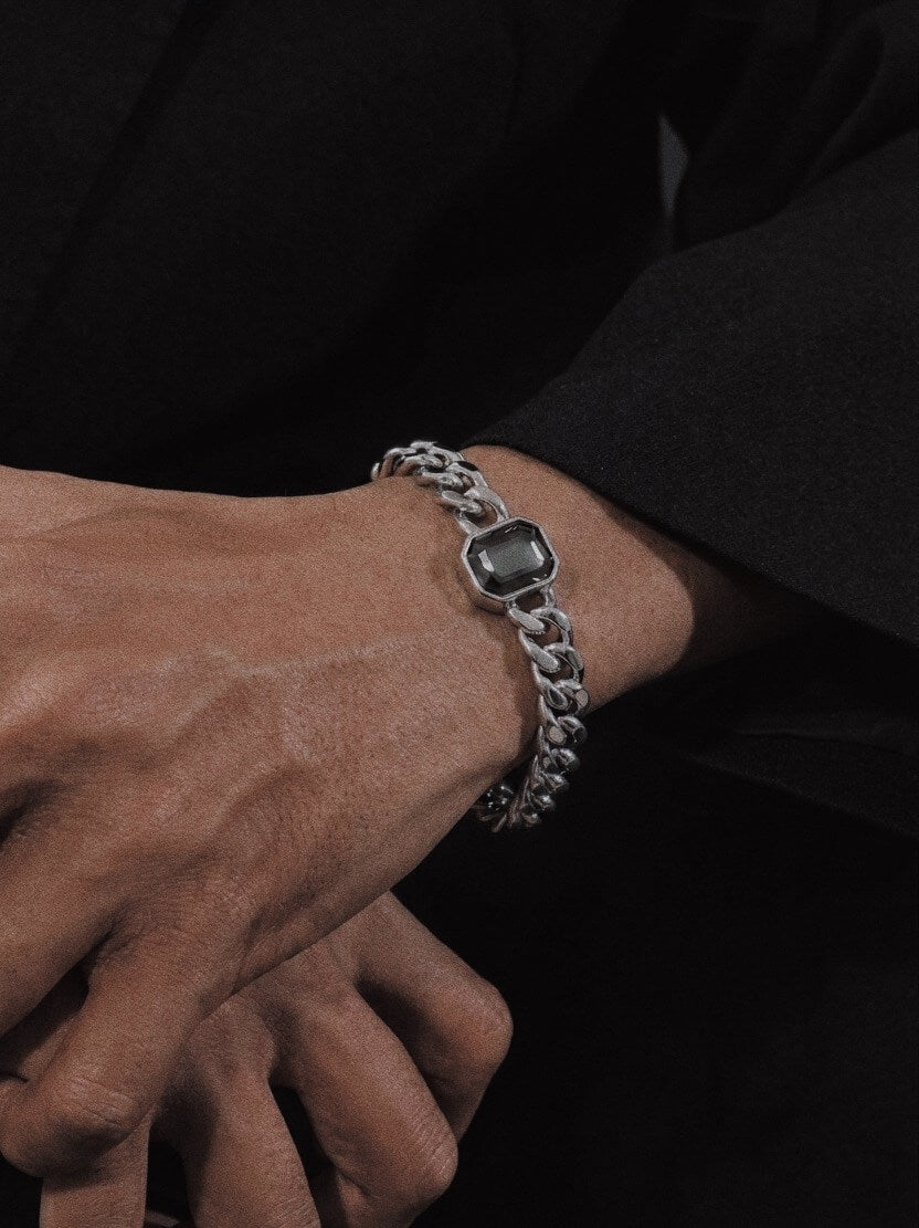 Model wearing grey zircon Cuban link bracelet, modern masculine streetwear fashion, waterproof stainless steel wristwear.
