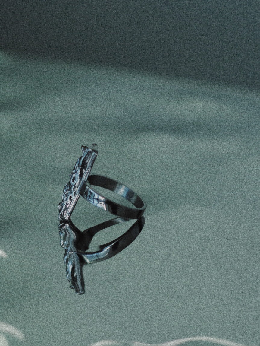 Side view of Monora Studio durable titanium steel architectural statement ring on a reflective mirror⁠