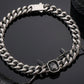 Emerald-cut grey gemstone on 316L stainless steel Cuban link bracelet, industrial aesthetic jewelry by Monora Studio.