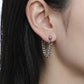 Model wearing a draped curb chain earring, soft grunge aesthetic ear stack, hypoallergenic stainless steel jewelry for sensitive ears.