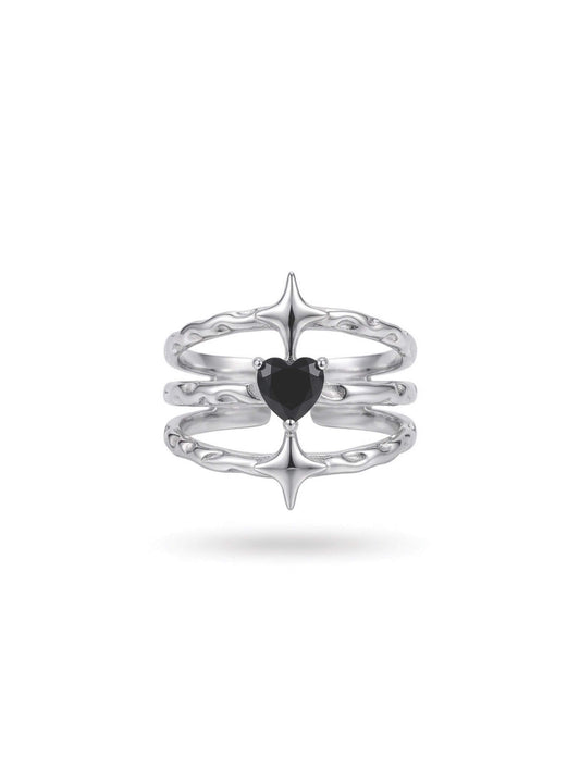 Product view of Monora Studio liquid metal ring featuring three-tier band, starburst spikes, and heart-cut black gemstone.