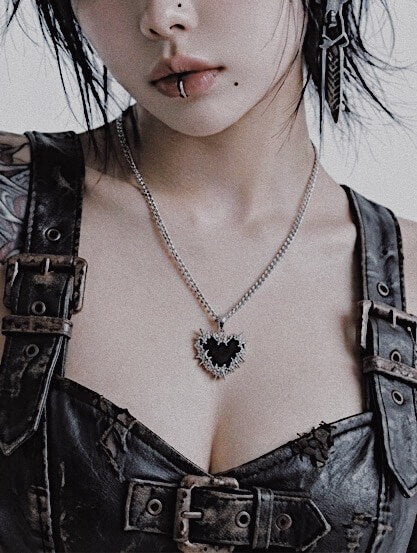 Model wearing gothic thorn heart necklace, Y2K grunge streetwear style, durable stainless steel jewelry for darkwear.
