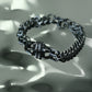 Monora Studio heavy stainless steel Cuban link bracelet with textured industrial knot reflecting on fluid water surface⁠