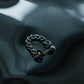 Industrial silver curb chain stud earring on a dark liquid reflective background, tarnish-proof stainless steel jewelry, Monora Studio aesthetic shot.