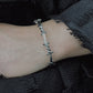 Model wearing Monora Studio punk style barbed wire open cuff bracelet with alt clothing streetwear outfit⁠