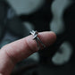 Close-up of a silver knot ring for women on finger, minimalist stainless steel double band adjustable jewelry, Monora Studio lifestyle.